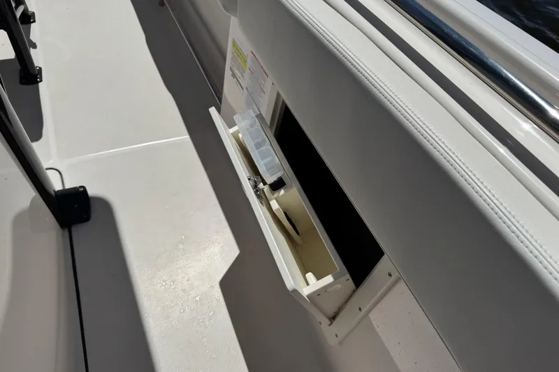 Slide: The Image of 2022 Robalo R242 Center Console boat with open storage compartment. - 26