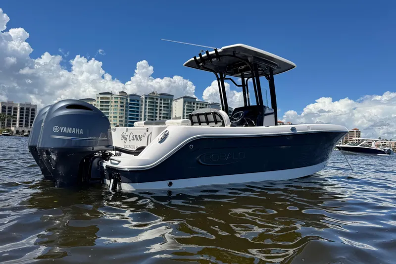 Slide: The Image of 2022 Robalo R242 Center Console boat on water with Yamaha engine, cityscape background. - 4