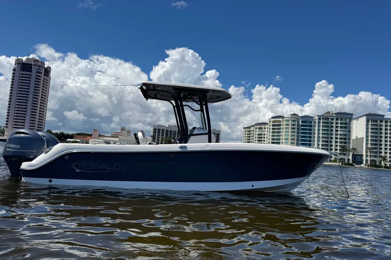 Slide: The Image of 2022 Robalo R242 Center Console boat on water, cityscape background, clear sky. - 5