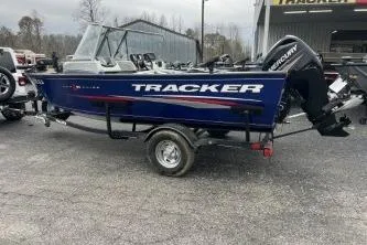 Slide: The Image of 2018 Tracker Pro Guide V-16 WT boat on trailer, blue exterior, parked outdoors. - 11