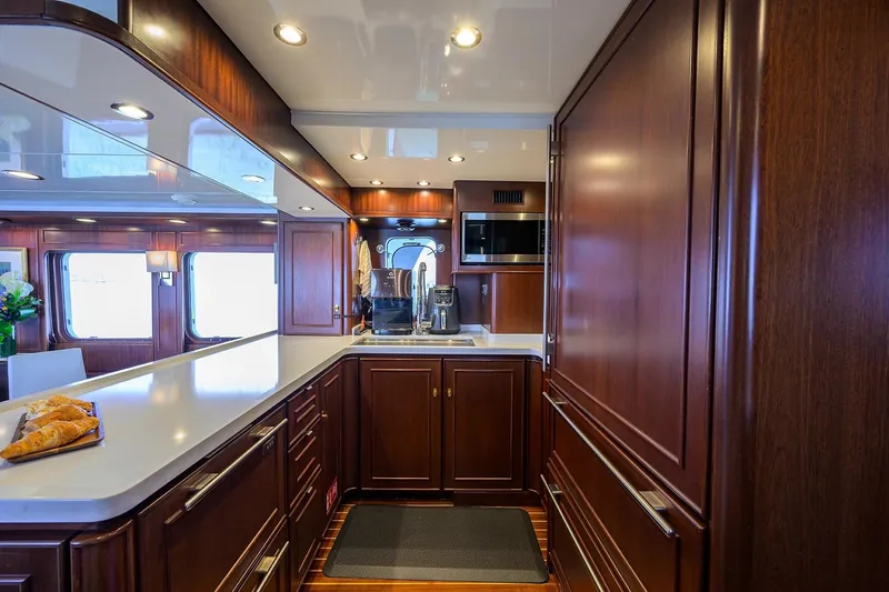 Slide: The Image of Luxurious 1986 Jongert 85 yacht kitchen with elegant wood cabinetry and modern appliances. - 16