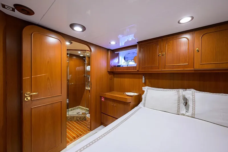 Slide: The Image of Luxurious wooden cabin interior on 1986 Jongert 85 yacht, featuring elegant bedding and cabinetry. - 34