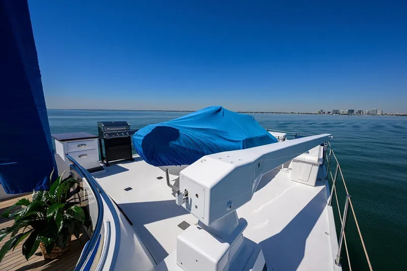 Slide: The Image of Deck of 1986 Jongert 85 yacht with covered equipment, ocean view, and city skyline. - 38