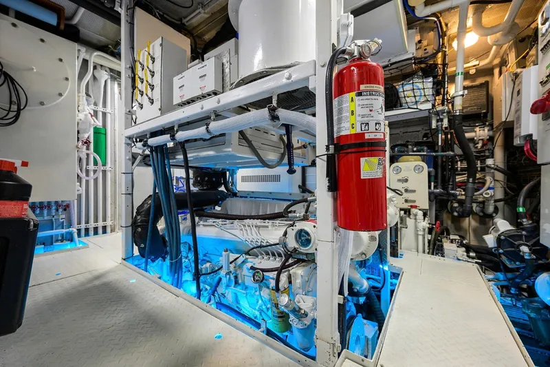 Slide: The Image of Engine room of a 1986 Jongert 85 yacht, featuring machinery and fire extinguisher. - 49