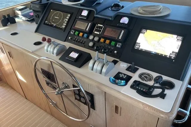 Slide: The Image of 1997 Hatteras 70 Sport Deck Motor Yacht helm with navigation controls and steering wheel. - 14