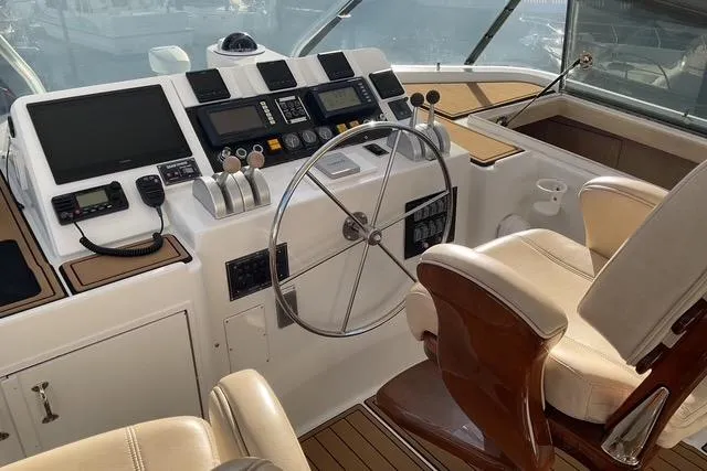 Slide: The Image of 1997 Hatteras 70 Sport Deck Motor Yacht helm with modern controls and leather seating. - 20