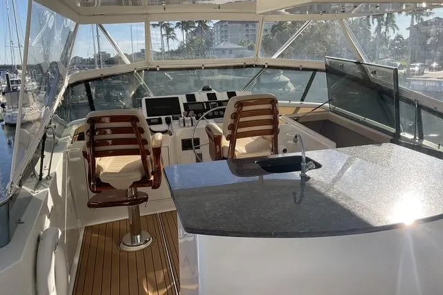 Slide: The Image of 1997 Hatteras 70 Sport Deck Motor Yacht helm with seating and countertop. - 22