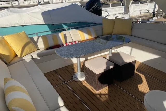 Slide: The Image of Luxurious seating area on 1997 Hatteras 70 Sport Deck Motor Yacht with cushions and table. - 23