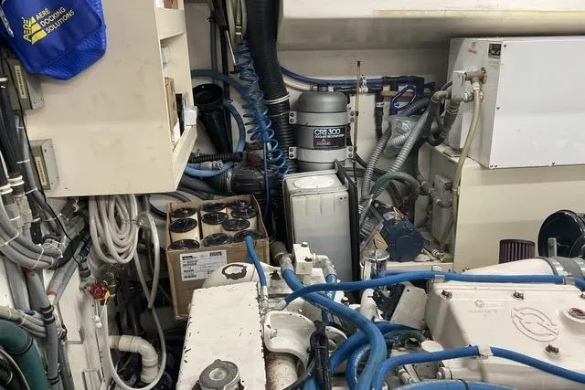 Slide: The Image of Engine room of a 1997 Hatteras 70 Sport Deck Motor Yacht with visible machinery and cables. - 48