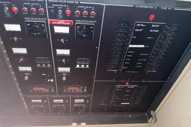 Slide: The Image of Electrical panel of a 1997 Hatteras 70 Sport Deck Motor Yacht, featuring various switches and meters. - 51
