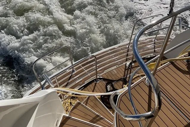 Slide: The Image of Stern view of 1997 Hatteras 70 Sport Deck Motor Yacht with teak steps and ocean waves. - 6