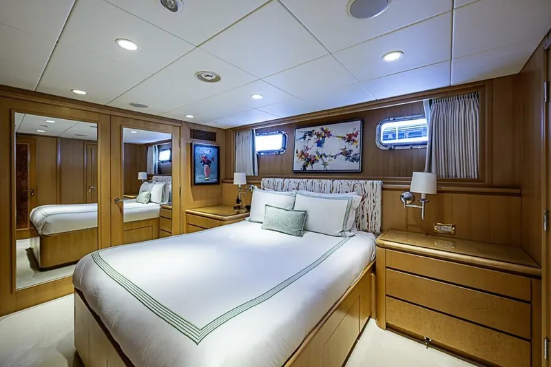 Slide: The Image of Luxurious bedroom on 1997 Delta 122 Tri-Deck Motor Yacht with elegant wood paneling. - 51