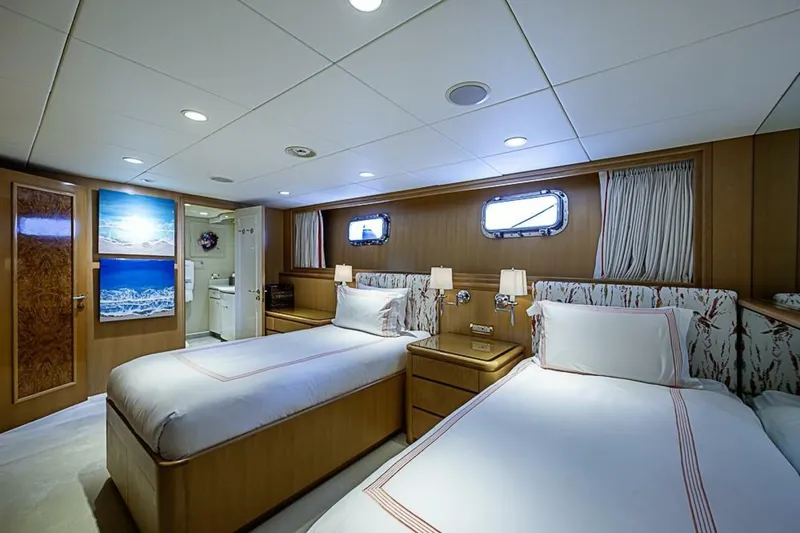 Slide: The Image of Luxurious twin bedroom on 1997 Delta 122 Tri-Deck Motor Yacht, featuring elegant decor and ocean artwork. - 54