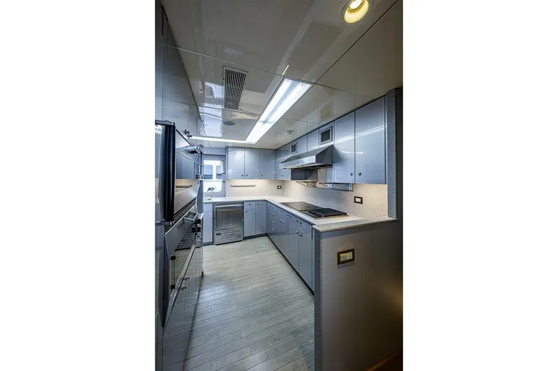 Slide: The Image of Modern kitchen interior on 1997 Delta 122 Tri-Deck Motor Yacht, featuring sleek cabinetry and appliances. - 63