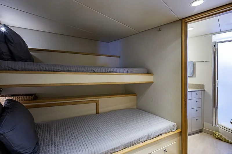 Slide: The Image of Bunk beds in a 1997 Delta 122 Tri-Deck Motor Yacht cabin with adjacent bathroom. - 67