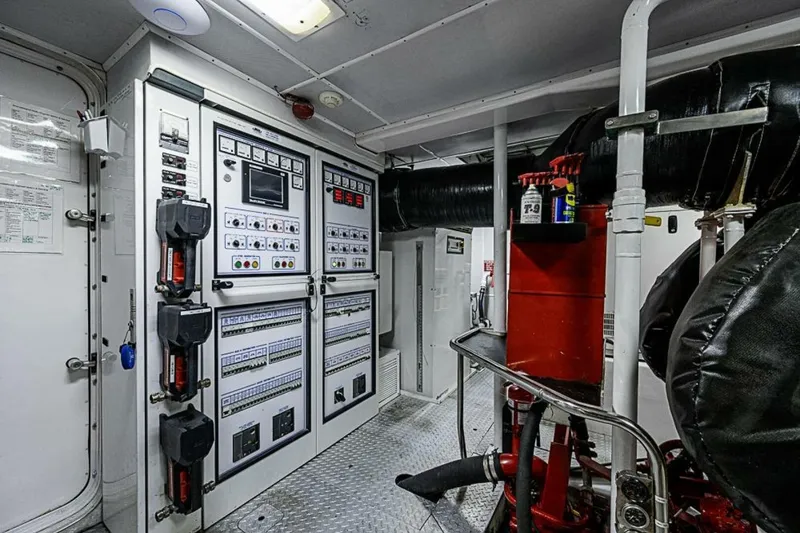 Slide: The Image of Engine room of 1997 Delta 122 Tri-Deck Motor Yacht with control panels and equipment. - 69