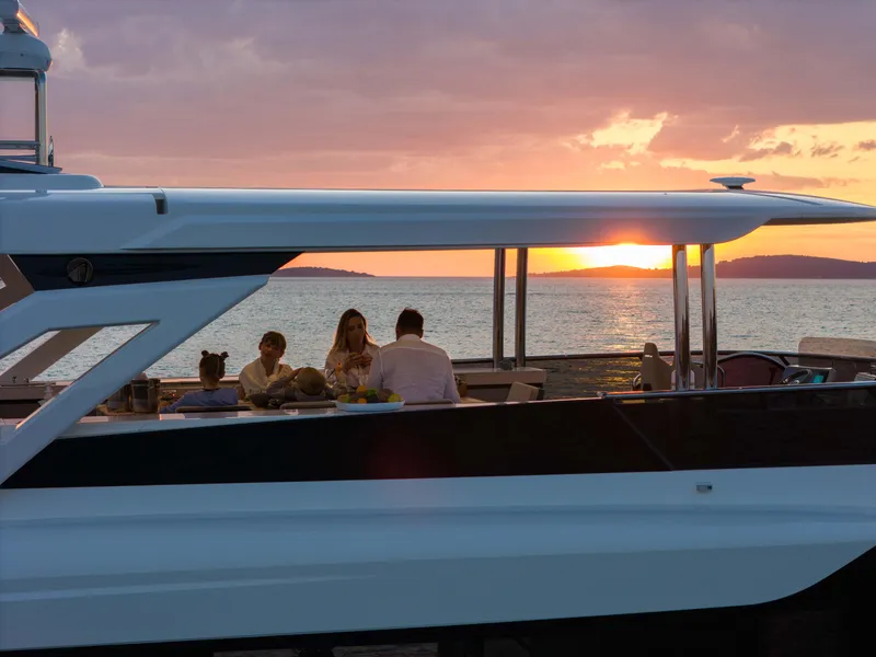 Slide: The Image of 2026 Absolute Navetta Co Ownership yacht at sunset with people enjoying the view. - 15