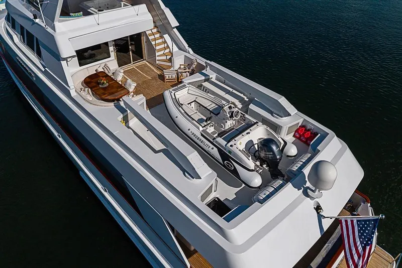 Slide: The Image of Luxurious 1997 Delta Marine yacht with spacious deck and tender boat, flying American flag. - 10