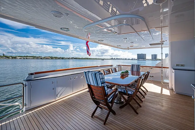 Slide: The Image of Luxurious Delta Marine yacht deck with dining area, overlooking serene waters, built in 1997. - 13