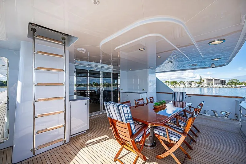 Slide: The Image of Luxurious 1997 Delta Marine yacht deck with dining area and scenic waterfront view. - 14