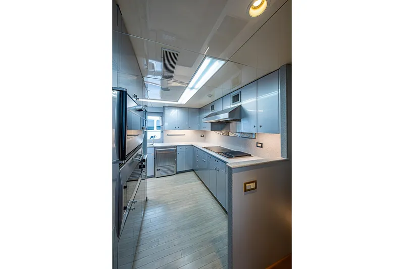 Slide: The Image of Modern yacht kitchen with sleek cabinetry, stainless steel appliances, and bright lighting, Delta Marine 1997. - 57
