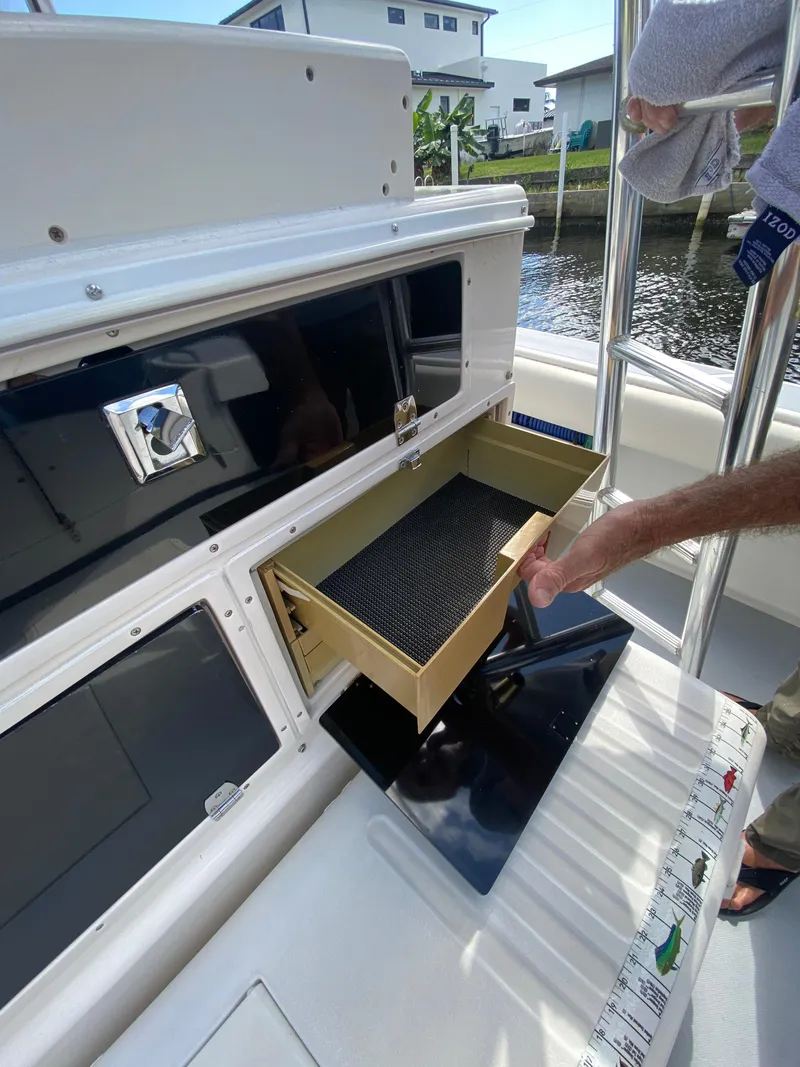 Slide: The Image of Person opening a drawer on a 1995 Ocean Master 3100 boat, dockside view. - 13