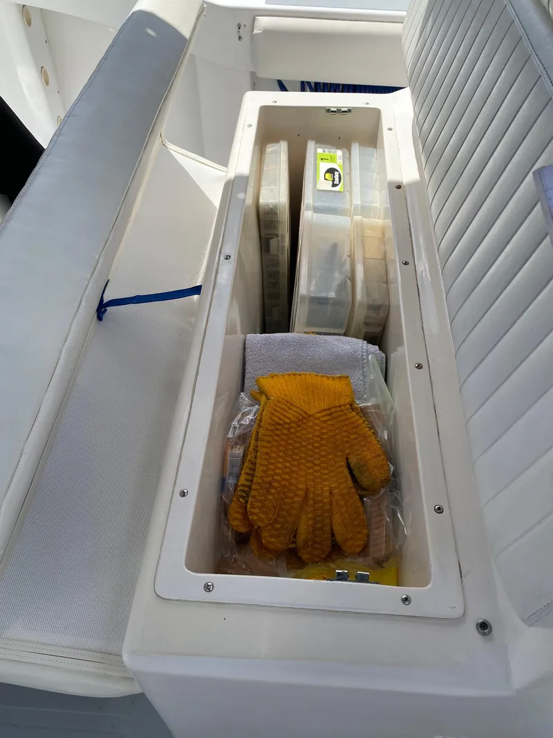 Slide: The Image of Storage compartment on a 1995 Ocean Master 3100 boat with gloves and tackle boxes. - 16