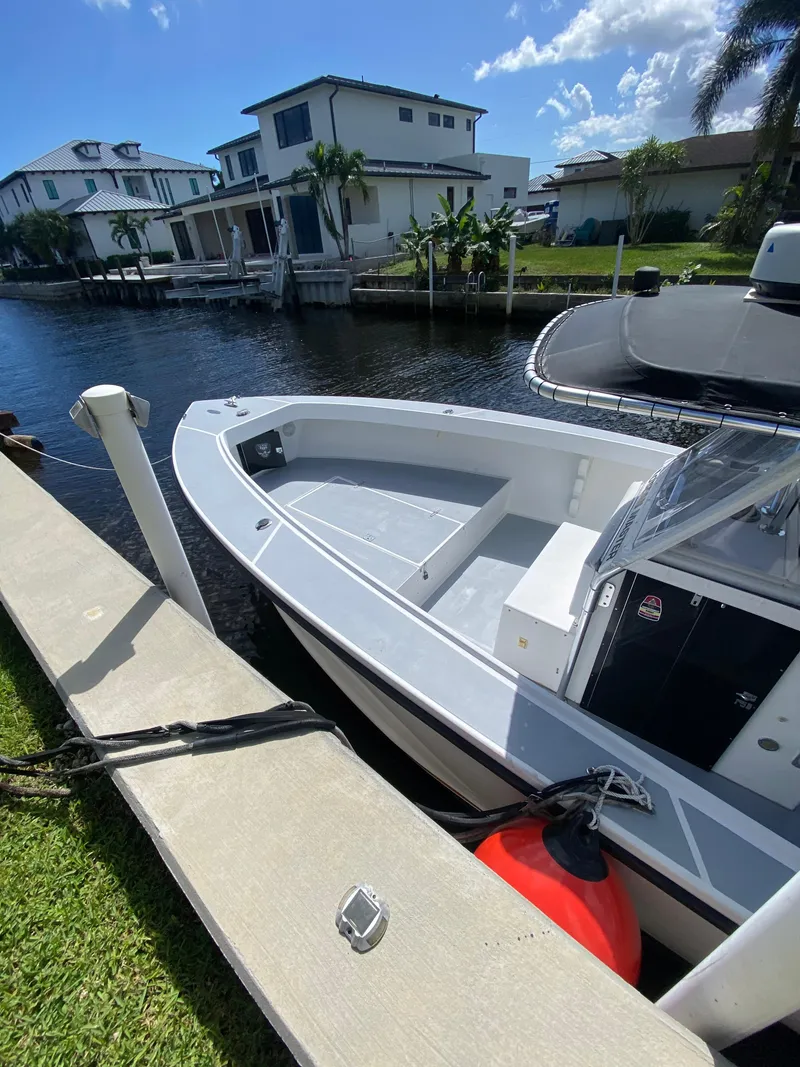 Slide: The Image of Ocean Master 3100 boat docked by waterfront homes under a clear blue sky. - 2