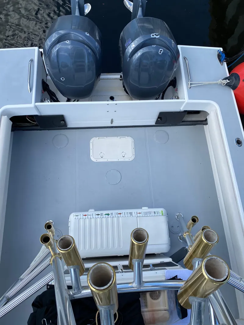 Slide: The Image of 1995 Ocean Master 3100 boat deck with dual engines and rod holders. - 20