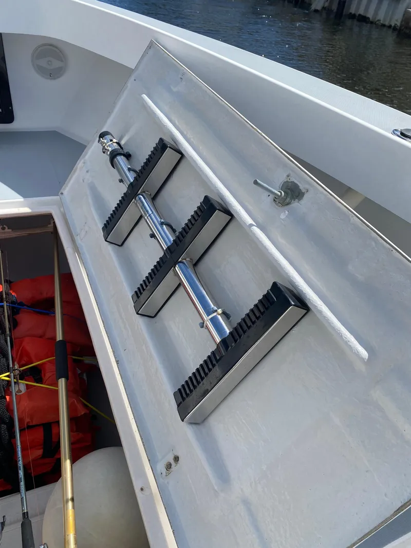 Slide: The Image of Storage compartment on a 1995 Ocean Master 3100 boat, featuring fishing rod holders. - 4