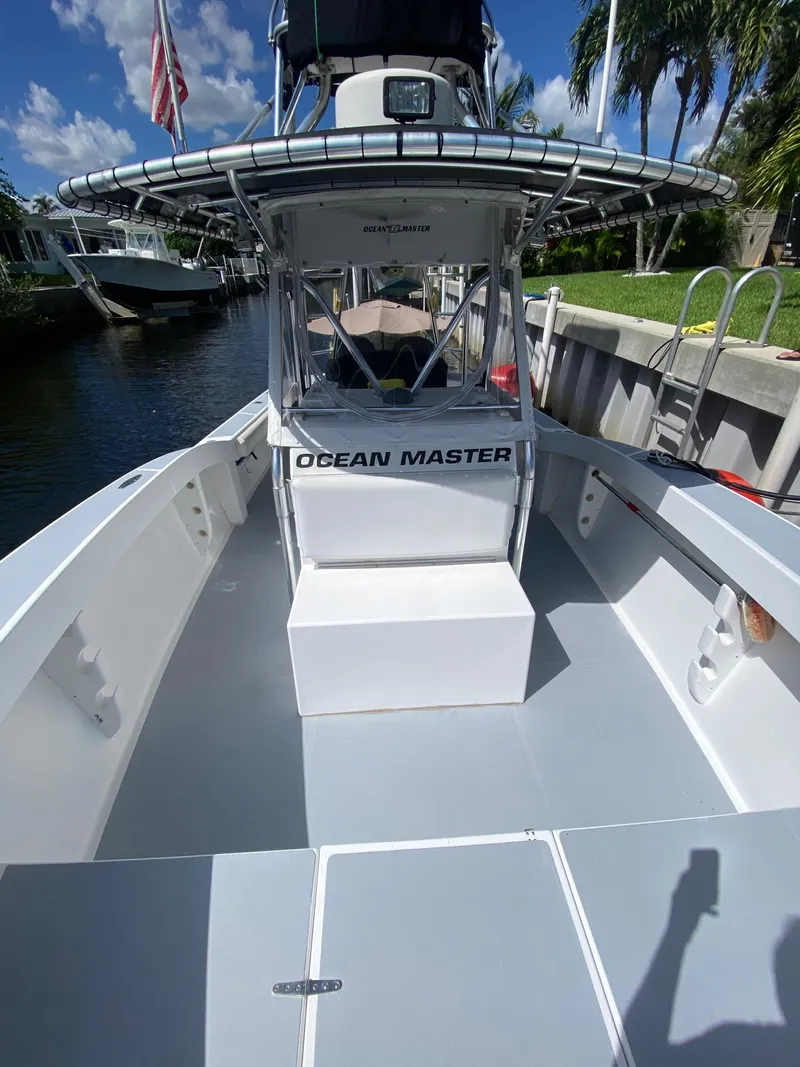 Slide: The Image of Ocean Master 3100 boat, 1995 model, docked by a canal under a clear blue sky. - 6