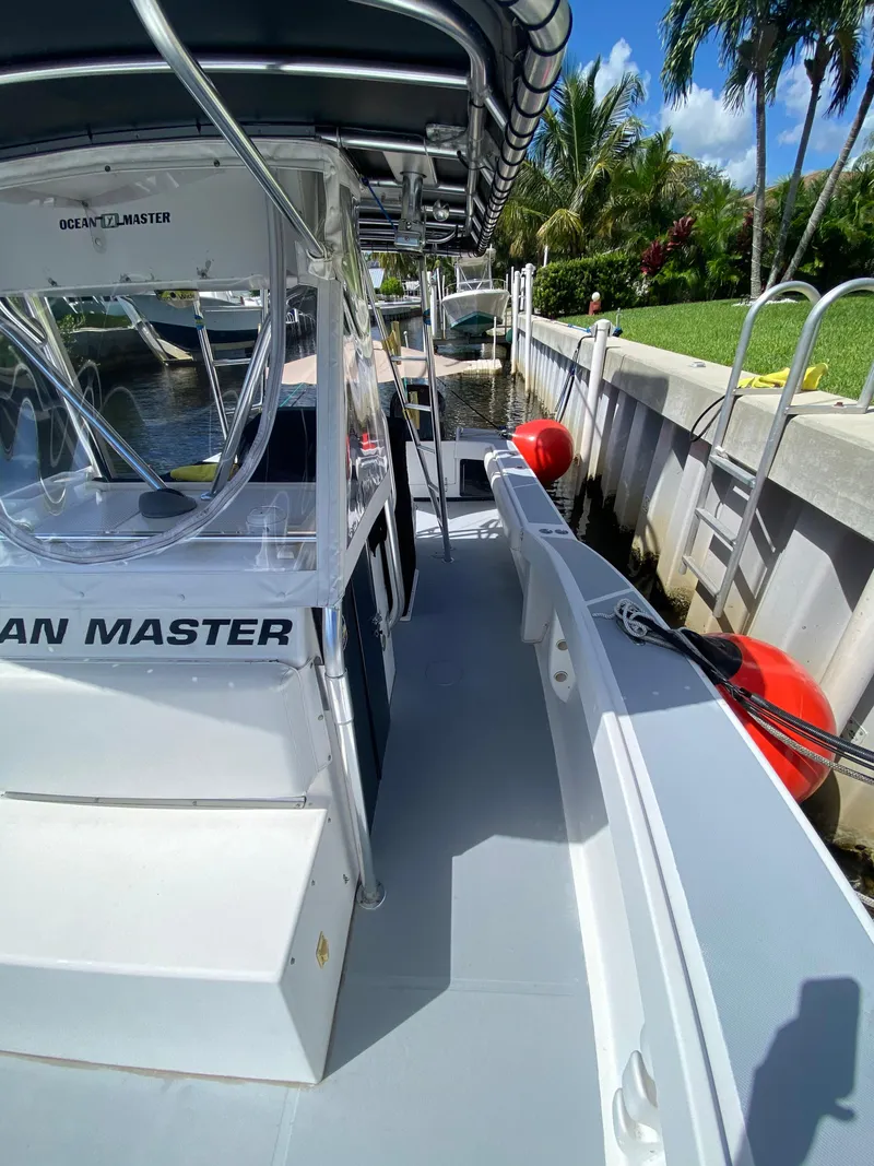 Slide: The Image of 1995 Ocean Master 3100 boat docked, featuring sleek design and spacious deck. - 7