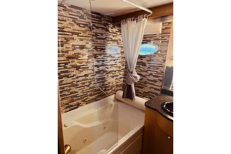 Slide: The Image of Luxurious bathroom in 1996 Forbes Cooper pilot house with mosaic tile wall and jacuzzi tub. - 14