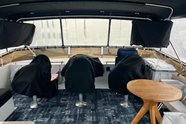 Slide: The Image of 1996 Forbes Cooper pilot house interior with covered seats and wooden table. - 19