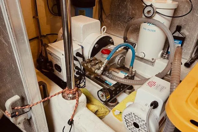 Slide: The Image of Engine room of a 1996 Forbes Cooper pilot house boat, featuring mechanical equipment and hoses. - 20