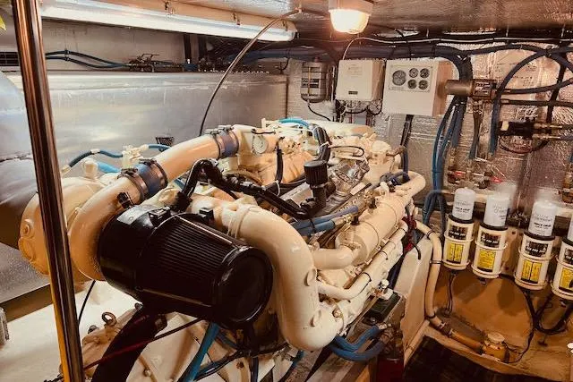 Slide: The Image of Engine room of a 1996 Forbes Cooper pilot house yacht, showcasing complex machinery and wiring. - 23