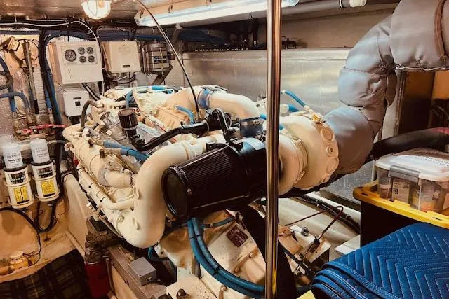 Slide: The Image of Engine room of a 1996 Forbes Cooper pilot house boat, showcasing complex machinery and wiring. - 24