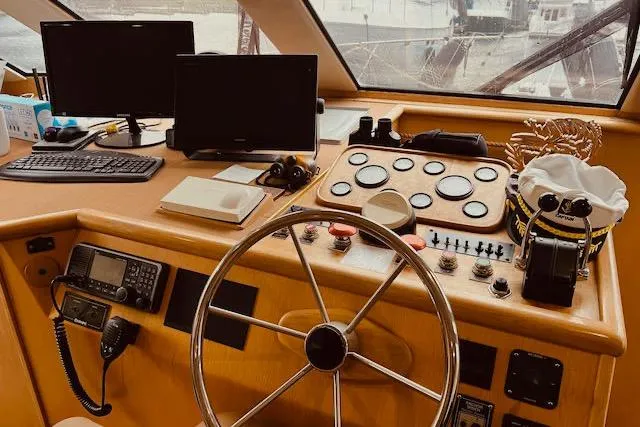 Slide: The Image of 1996 Forbes Cooper pilot house interior with steering wheel, control panels, and navigation equipment. - 6
