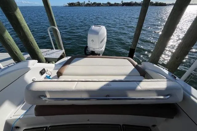Slide: The Image of 2019 Cobalt 25SC boat interior with white and brown seating, overlooking water. - 11