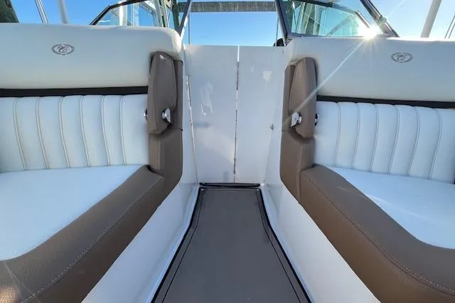 Slide: The Image of 2019 Cobalt 25SC boat interior with white and brown seating, docked by the water. - 15