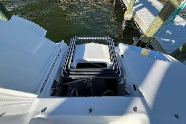 Slide: The Image of 2019 Cobalt 25SC boat with a folded swim ladder at the stern, dockside view. - 20