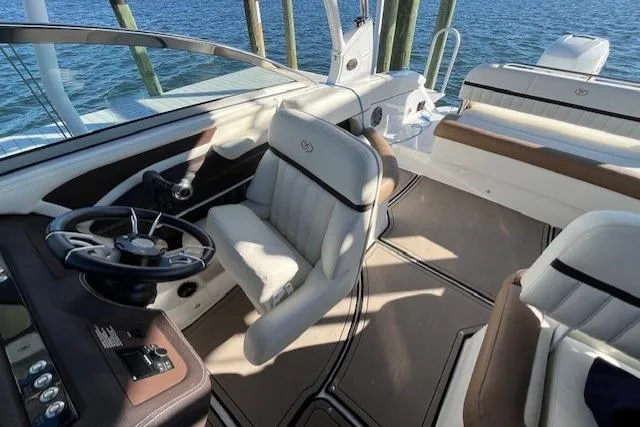 Slide: The Image of 2019 Cobalt 25SC boat docked, covered, with blue canopy, sunny day. - 6