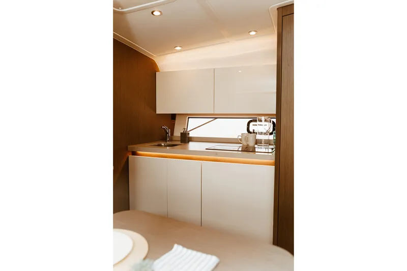 Slide: The Image of Modern kitchen interior of 2023 Beneteau Gran Turismo 41 yacht, featuring sleek cabinetry and lighting. - 13