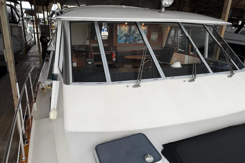 Slide: The Image of 1985 Bayliner 4550 Motoryacht with Raymarine radar under a wooden dock roof. - 104