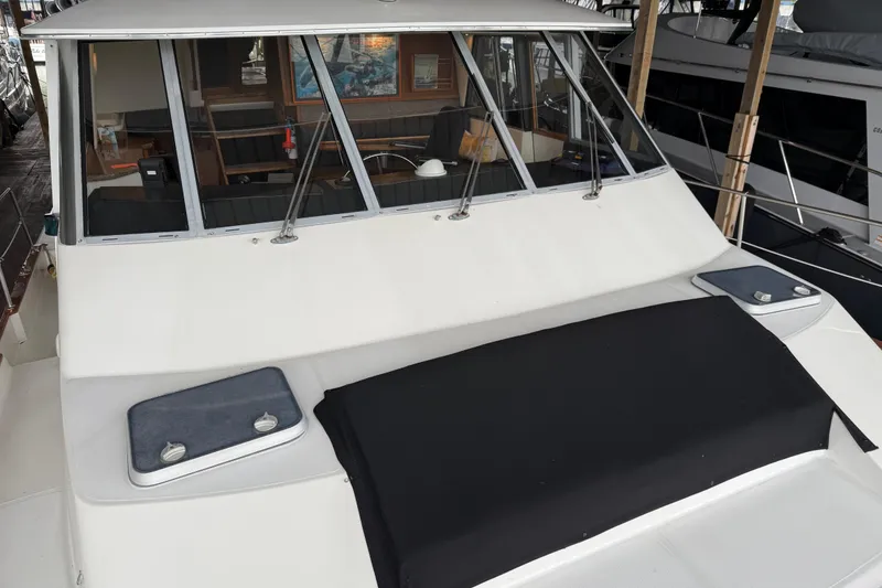 Slide: The Image of 1985 Bayliner 4550 Motoryacht docked, showcasing cabin windows and deck area. - 106