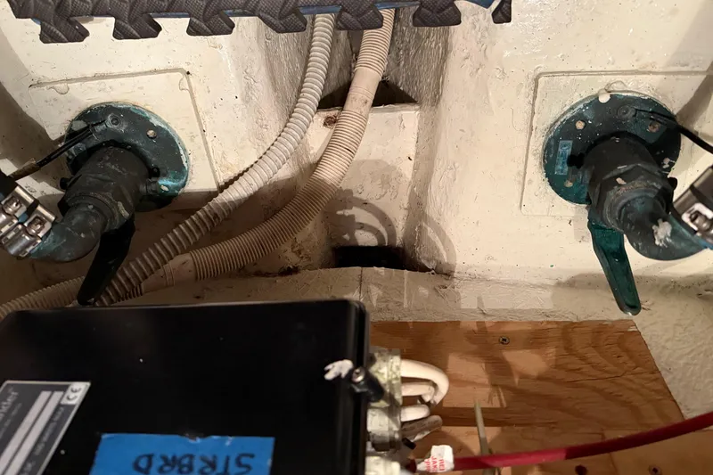 Slide: The Image of Engine compartment of a 1985 Bayliner 4550 Motoryacht, showcasing mechanical components and hoses. - 120