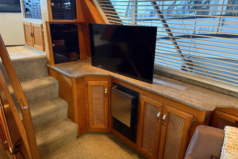 Slide: The Image of Cozy seating area on 1985 Bayliner 4550 Motoryacht with brown armchairs and decorative pillows. - 16