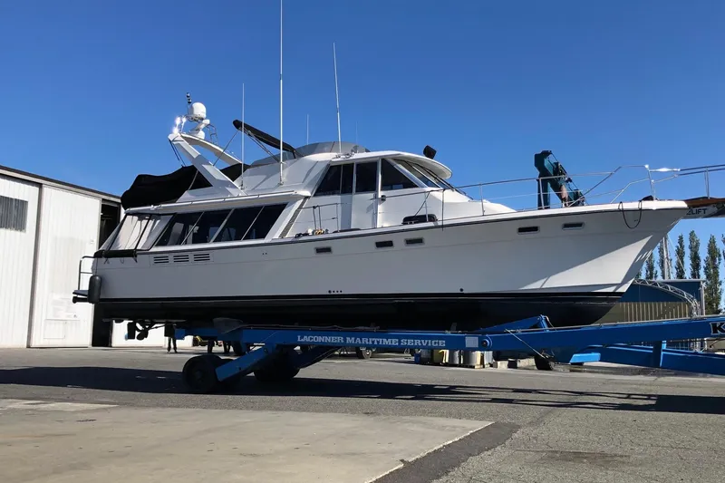 Slide: The Image of 1985 Bayliner 4550 Motoryacht anchored in scenic forested waters. - 2