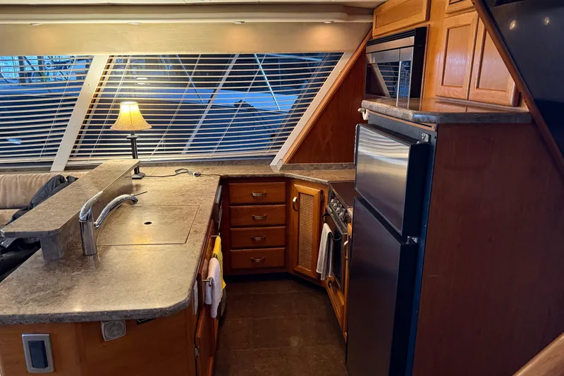 Slide: The Image of Luxurious 1985 Bayliner 4550 Motoryacht kitchen with modern appliances and elegant wood finishes. - 25