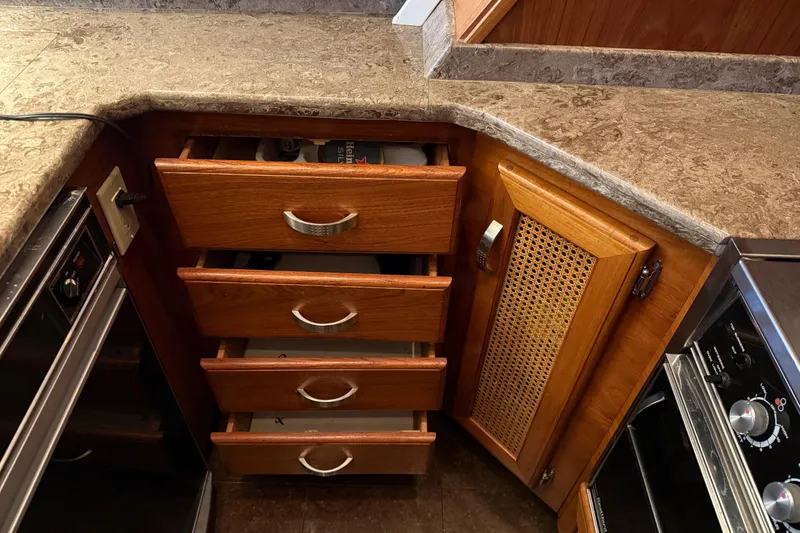 Slide: The Image of Open wooden cabinet on 1985 Bayliner 4550 Motoryacht with marble countertop. - 38